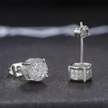 Macro shot of silver iced out round stud earrings with shimmering white zircon stones - White Gold