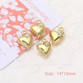 Macro view of gold heart pendants with rhinestones and scalloped edges, 14x10mm size - Heart / Gold