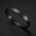Dettaglio di un bracciale rigido in metallo nero con numeri romani incisi su sfondo scuro - Numeri Romani / Nero