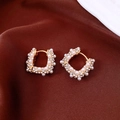 Vista macro di orecchini a U placcati oro 18k con strass e perle bianche eleganti - Huggie a Forma di U (Placcato Oro) / Oro/Bianco