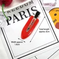 Detail of a 6cm red teardrop hair clip with a smooth glossy finish and metal duckbill clip - Red