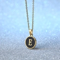 Golden round pendant necklace with black enamel inlay featuring a stylized letter E - Letter E