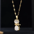 Golden cat pendant necklace with cat eye stone and crystal bow on a twisted chain - 9055 White Cat