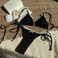 Detailopname van zwarte kant bikini met witte geschulpte rand en strikdetail op de top - S / Zwart