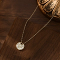 Close-up of gold plated starburst necklace with micro-pave zircons on a dark wood background - Gold