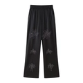 Detail of black satin wide-leg pants with shimmering rhinestone floral embroidery - XS / Bottoms / Black
