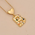 Close-up of golden heart pendant with a colorful zircon letter B on a beige background - Letter B / Gold