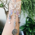 Detailed close-up of a butterfly suncatcher with silver stars, moons and crystal pendants - Labradorite