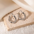 Détail macro de créoles torsadées en argent en acier inoxydable 304 poli pour femmes - Style Torsadé Irrégulier Argent (JJE0024)