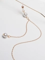 Close-up of golden metal eyeglass chain with white pearls and anti-slip rubber loops - Gold