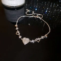 Macro shot of adjustable silver heart bracelet with sparkling zircon and shell inlay - Silver