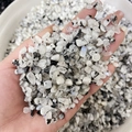 Hand holding polished black and white moonstone chips with natural blue sheen - Black Spotted Moonstone / 7-9mm 100g