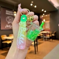 Detail of cute bubble tea keychain with green liquid, glitters and a soft PVC wrist strap - Green Luminous Bubble Bead Milk Tea Cup