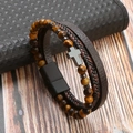 Detail of tiger eye stone beads and braided leather bracelet with a metal cross charm - Coffee + Tiger Eye