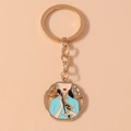 Détail d'un porte-clés doré octogonal avec motif de dame en cheongsam bleu émaillé - Dame Cheongsam Verte