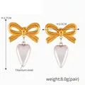 Titanium stalen oorbellen met gouden strik en zilverkleurige hartvormige hanger - F1518 / Goud & Zilver
