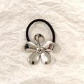 Silver metallic flower hair tie with black elastic band on textured paper background - Silver Clover 5cm