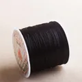 Macro detail of high-gloss black elastic crystal string on a spool for DIY jewelry making - Black