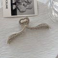 Dettaglio macro della pinza per capelli a cuore dorata con perle e strass su vassoio - Stile Perla + Strass