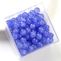 Macro shot of blue translucent round glass beads in a clear storage box for DIY jewelry - Dark Blue Apple Bead