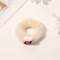 Close-up of beige plush Christmas scrunchie featuring a red snowflake glove charm - Plush Christmas Sock Hair Tie