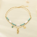 Détail d'un collier double rang doré avec hippocampe, étoile de mer, perles et turquoise - Style Hippocampe Étoile de Mer Turquoise (KN292176-SXSJ)