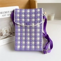 Detail of purple checkered knit crossbody bag with adjustable strap on a wooden shelf - Plaid Purple