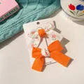 Set of two bow hair clips for girls, featuring white floral patterns and solid orange fabric - Orange Patchwork Bow Set