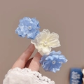Elegant mesh fabric hair clip with blue and white flowers and pearl centers in hand - Blue Triple Flower Hair Tie