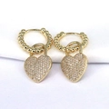 Macro-opname van gouden hartoorbellen met witte zirkonia en kralendetails op de ring - Wit