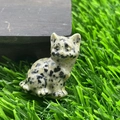 Hand-carved natural stone cat figurine with black spots on green grass surface - Spotted Stone
