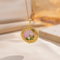 Elegante gouden bloemenketting met roze emaille en parelhanger op een warme achtergrond - Roze