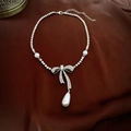 Macro view of silver bow necklace with rhinestones and teardrop pearl on brown silk - Bowknot Waterdrop Pearl Necklace (3#) / Silver