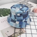 Detail view of denim patchwork bucket hat with white stitching on marble surface - Denim Patchwork