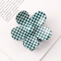 Top view of a green and white checkered flower claw clip on an open book page - Green/White Plaid Flower Clip