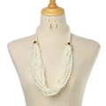 Detail of multi-layered pearl necklace and matching earrings set on a white stand - White