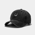 Close-up of vintage washed cotton baseball cap with white smiley face embroidery - Adjustable / Black