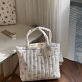 Gesteppte weiße Baumwolltasche mit süßen Comic-Mustern auf einem Holzhocker - Gestreifte Katze