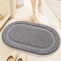 Absorbent grey oval bathroom rug with plush texture shown in a real home usage setting - Light Grey (Jianxin Series)