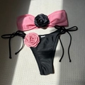 Close-up of color-block bikini with 3D roses and side-tie details on textured background - Peach