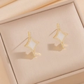 Elegant gold star earrings with white mother-of-pearl and small diamond accents - White Shell Stud Earrings (840)