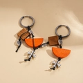 Ethnic retro wooden earrings with silver cross pendant on beige leather background - Orange Ear Hoop