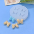 Detailansicht der weißen Silikonform mit 4 Schmetterlingsmotiven für DIY Tortendeko - 4-Hohlraum Runder Schleifen-Stil (1)