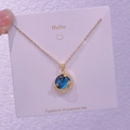 Dettaglio macro della collana luna dorata con pendente in gemma stellata blu e zirconi - Mezzaluna Stellata (XK0036)