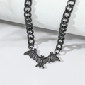 Detailansicht eines schwarzen Metall-Fledermausanhängers an einer groben Kette - Schwarz