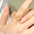 Minimalist golden stainless steel bow ring for women shown on a model hand - Gold Bow Ring (N-684)