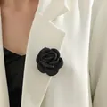 Detail einer handgefertigten schwarzen Stoffrose Brosche an einem weißen Blazer - Schwarz
