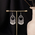 Ethnic bohemian silver tassel clip-on earrings displayed on a gold T-stand over black fabric - E4855-1 (Bohemian Ring Tassel)