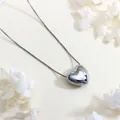 Detailed view of a silver heart-shaped pendant with a polished box chain on a textured surface - Silver Small 3D Heart