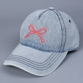 Detail der roten Schleifenstickerei auf hellblauer Denim-Baseballkappe mit Textur - M / Hellblau